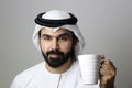 Portrait Of A Young Confident Arab Businessman Wearing UAE Emirati Tradational Dressn Holding A Mug  ARAB EMIRATI MODEL Royalty Free Stock Photo