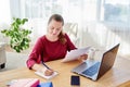 Portrait of young confident business woman sitting at wooden desk and writing plan in notebook at home office, copy space Royalty Free Stock Photo