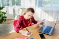 Portrait of young confident business woman sitting at wood desk and writing plan in notebook in modern  office, copy space. Royalty Free Stock Photo