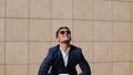 Portrait of young confident businessman tearing a legal documents. The man resigns from his job and smiles at camera