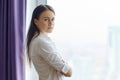 Portrait of young confident businesswoman with arms crossed near office window, female looking into camera smiling Royalty Free Stock Photo