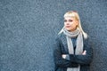 Portrait of young confident fashionable woman with cool attitude. Hipster stylish female posing against black wall