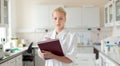 Portrait of young, confident female health care professional taking notes during inventory in scientific laboratory or Royalty Free Stock Photo