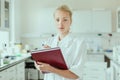 Portrait of young, confident female health care professional taking notes during inventory in scientific laboratory or Royalty Free Stock Photo