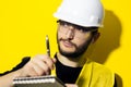 Portrait of young confident man, builder engineer writing in notebook, wearing safety helmet and glasses for construction, isolate Royalty Free Stock Photo