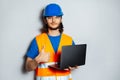 Portrait of young confident man, construction worker engineer wearing safety equipment, holding laptop and showing thumb up. Royalty Free Stock Photo