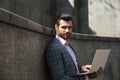 Portrait of young confident man in suit using laptop computer Royalty Free Stock Photo