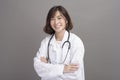 Portrait of young confident woman doctor isolated over grey background studio Royalty Free Stock Photo