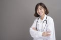 Portrait of young confident woman doctor isolated over grey background studio Royalty Free Stock Photo
