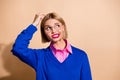 Portrait of young confused business woman in blue jumper scratching head look empty space forgot idea isolated on beige Royalty Free Stock Photo