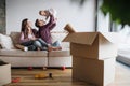 A portrait of young couple with a baby and cardboard boxes moving in a new home. Royalty Free Stock Photo