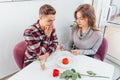 Portrait of young couple, concerned and pessimistic man and happy, excited, woman, who takes photos of food in cafe. Royalty Free Stock Photo