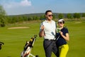 Young women and men playing golf at sunny day Royalty Free Stock Photo