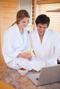 Portrait of a young couple having breakfast while using a laptop Royalty Free Stock Photo