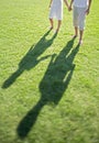 Portrait of Young couple holding hands while walking on grass at park Royalty Free Stock Photo