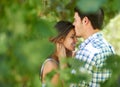 Portrait, young couple and kissing under the trees in the park and enjoying love in the summer sun. Cheerful, special Royalty Free Stock Photo