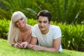 Portrait of young couple laying on green grass. Royalty Free Stock Photo