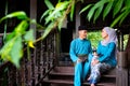 A portrait of young couple of malay muslim in traditional costume having conversation during Aidilfitri celebration at the
