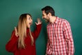 Portrait of young couple, man and woman, feeling and expressing excitement and happiness isolated over green background