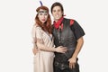 Portrait of young couple in old-fashioned costumes smiling against gray background Royalty Free Stock Photo