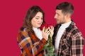 Portrait of a young couple with red roses on a red background. Valentine`s holiday concept Royalty Free Stock Photo