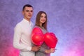 Portrait of young couple with red shape heart air balloons. Valentine`s day celebration concept Royalty Free Stock Photo