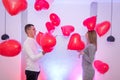Portrait of young couple with red shape heart air balloons. Valentine`s day celebration concept Royalty Free Stock Photo