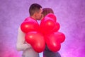 Portrait of young couple with red shape heart air balloons. Valentine`s day celebration concept Royalty Free Stock Photo