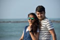 Portrait of young couple in the sea beach enjoying honeymoon time. Closeup of beautiful woman leaning on boyfriend Royalty Free Stock Photo