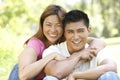 Portrait Of Young Couple Sitting In Park