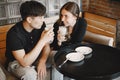 Young couple holding a cups of cappuccino in a restaurant