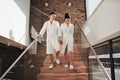 Portrait of young couple in spa resort, walking down the stairs. Royalty Free Stock Photo