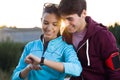 Portrait of young couple using they smartwatch after running. Royalty Free Stock Photo