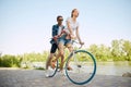 Portrait of young couple, woman and her boyfriend going for a bike ride in river enbankment on summer day. Romantic date Royalty Free Stock Photo
