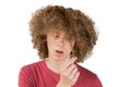 Portrait of a young curly european man frightened looks at his long hair. holds a curl of hair with his fingers. very lush male Royalty Free Stock Photo