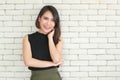 Portrait of young and cute Asian woman standing against white brick wall crossed arms in self-confident pose and smile with Royalty Free Stock Photo