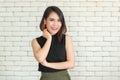 Portrait of young and cute Asian woman standing against white brick wall crossed arms in self-confident pose and smile with Royalty Free Stock Photo