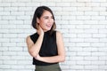 Portrait of young and cute Asian woman standing against white brick wall crossed arms in self-confident pose and smile with Royalty Free Stock Photo