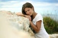 Portrait of a young cute girl on a seashell stone