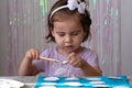 Portrait of a young cute kid girl holding a paintbrush and painting painting at the table. Creativity, education, child Royalty Free Stock Photo