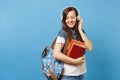 Portrait of young cute relaxed woman student in denim clothes with backpack headphones listen music, hold school books Royalty Free Stock Photo