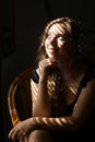 Portrait of young cute woman sitting in chair, striped shadows. Royalty Free Stock Photo