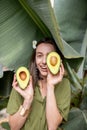 Woman with avocado in banana leaves Royalty Free Stock Photo