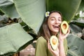 Woman with avocado in banana leaves Royalty Free Stock Photo