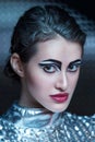 Portrait of young cyber woman in silver futuristic costume with bright makeup.