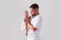 Portrait young Dad holding newborn baby girl in pink dress on white background. Happy father& x27;s day. Space for text Royalty Free Stock Photo