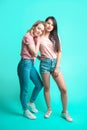 Eenage girlfriends, caucasian woman and Asian woman - isolated on blue background Royalty Free Stock Photo