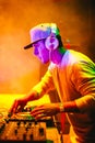 Portrait of Young DJ playing mixing music at night party under colorful lights. Royalty Free Stock Photo