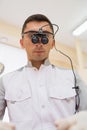 Portrait of Young doctor with dental binocular loupes on his face at dentist clinic.