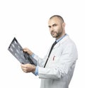 Portrait of a young doctor looking at an xray exam isolated on white